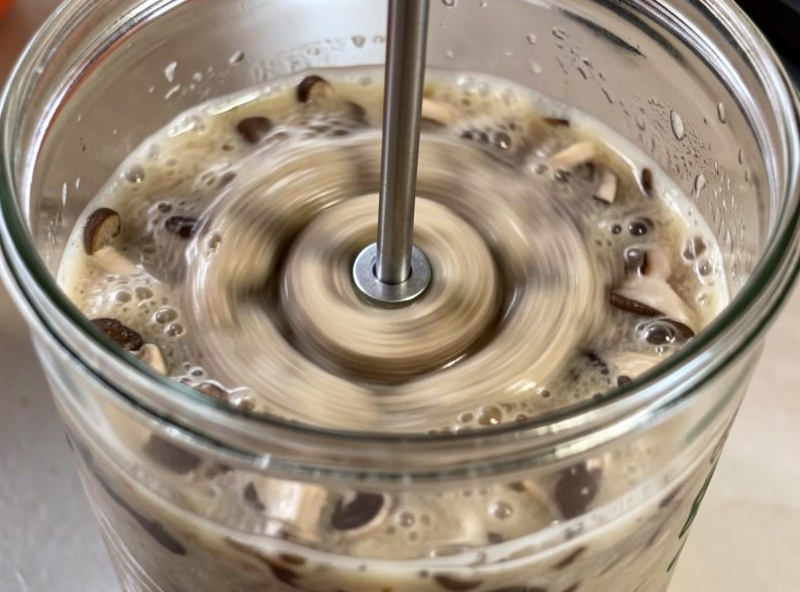 Magnetic stir plate spinning a vortex in a jar of cloudy liquid culture broth