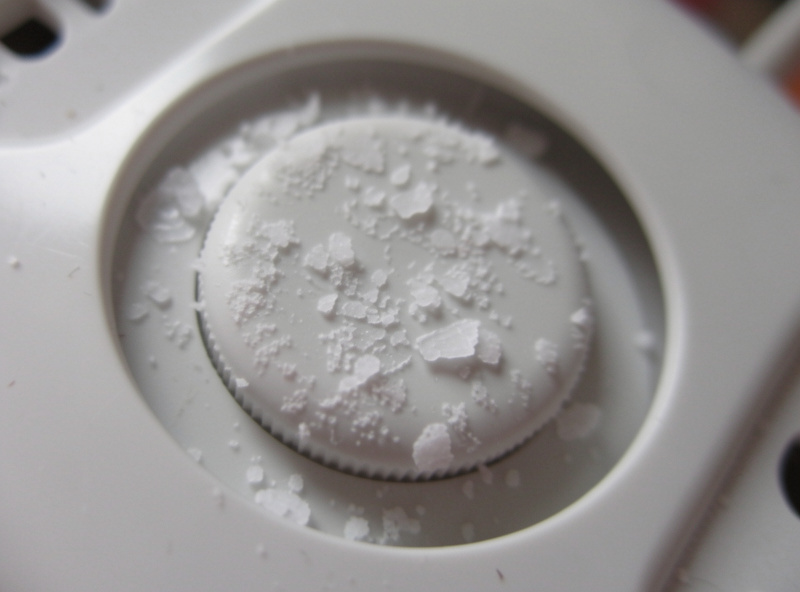 White mineral scale crusted on the transducer disc of an ultrasonic humidifier